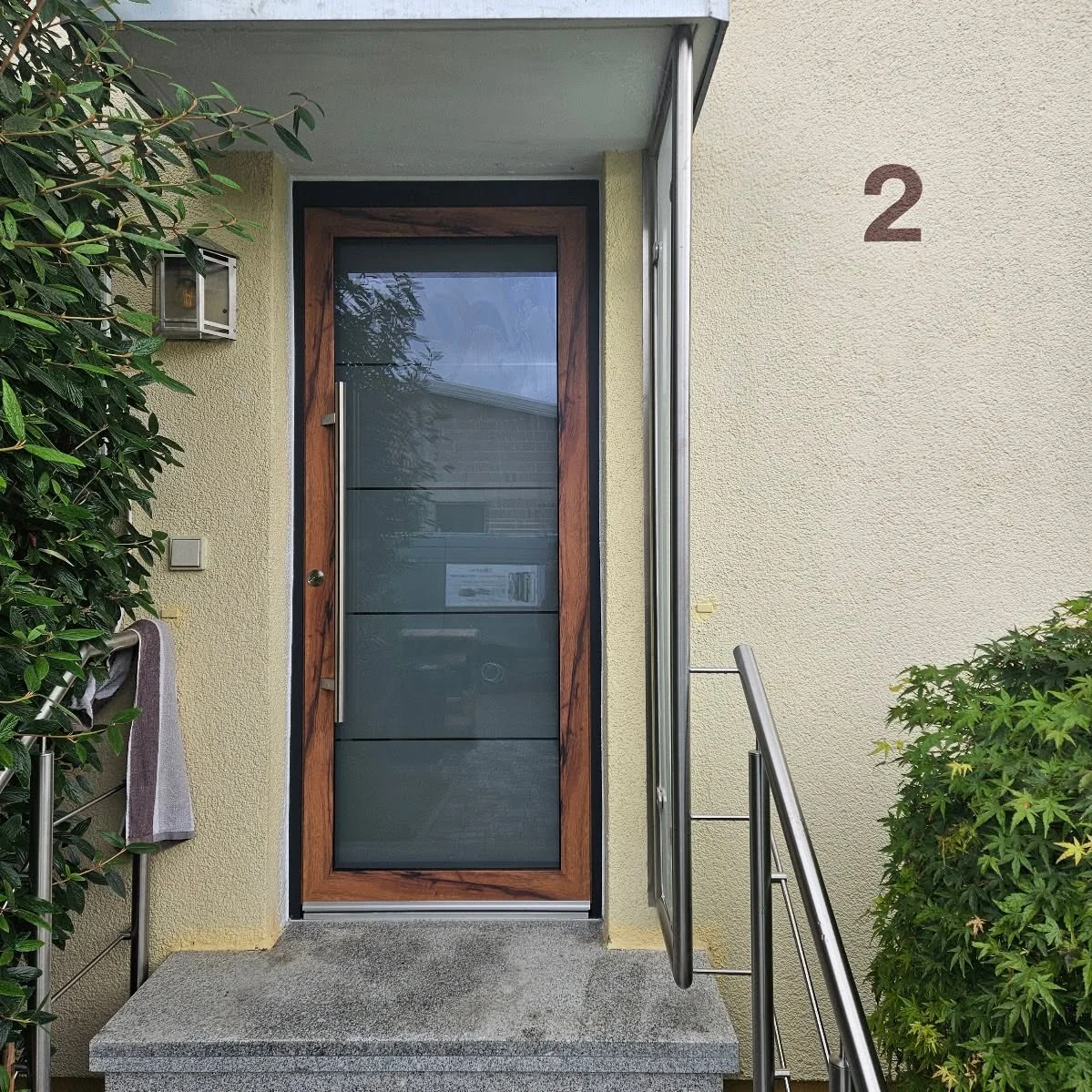 Haustür in edlem Holzdekor mit lebendiger, rötlich-brauner Maserung