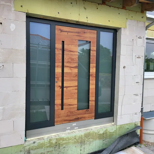 Aluminium-Haustür in RAL 7016 Anthrazitgrau mit prachtvollem Eiche-Holzdekor und zwei vertikalen Glasausschnitten