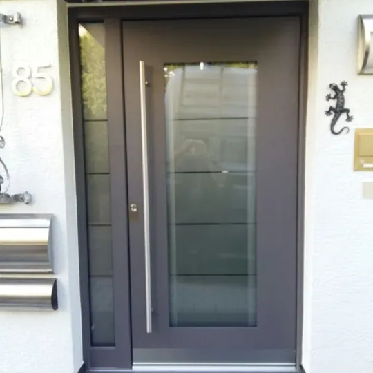 Dunkelgrau-braune Haustür mit großem Glasfeld und Seitenteil