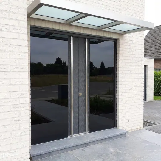 Dunkle Glas-Eingangsanlage an heller Klinkerfassade