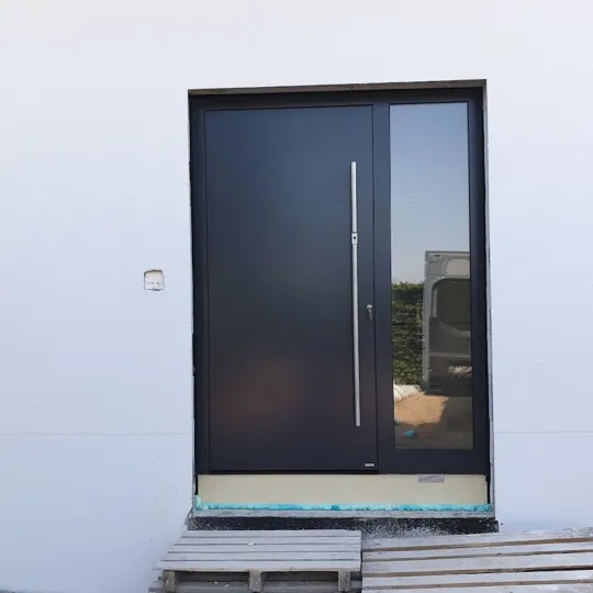 Dunkle Haustür mit Klarglas-Seitenteil am Neubau