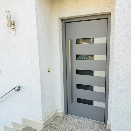 Graue Haustür mit versetzten Glasausschnitten