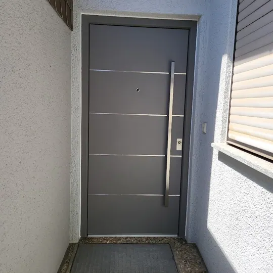 Inotherm Exclusiv Aluminium-Haustür in RAL 7037 Staubgrau mit fünf feinen Edelstahl-Zierleisten
