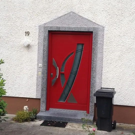 Rote Haustür mit geschwungenem Glaselement