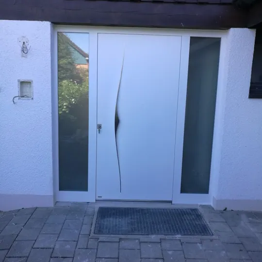 Weiße Designtür mit geschwungenem Griffelement und Seitenteilen