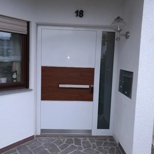 Weiße Haustür mit Holzoptik-Band und Quergriff