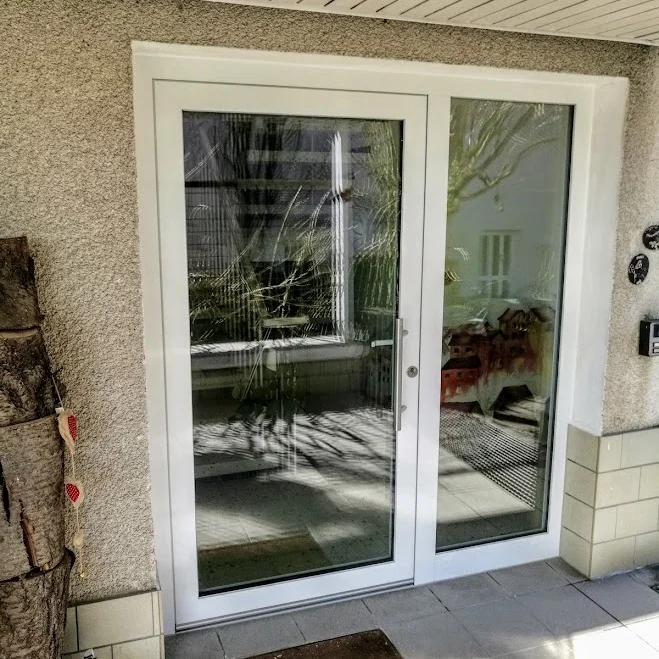 Weiße zweiflügelige Inotherm Eingangsanlage mit Glas